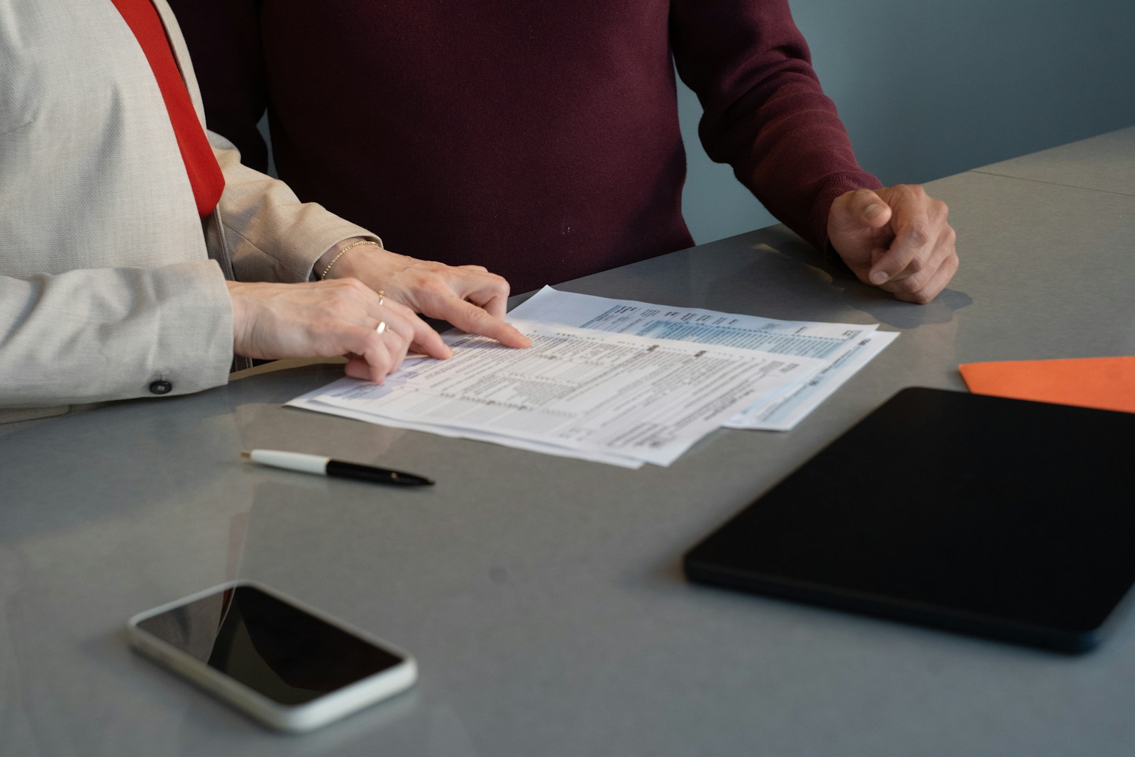 Dos personas revisan documentos sobre una mesa durante una reunión de trabajo