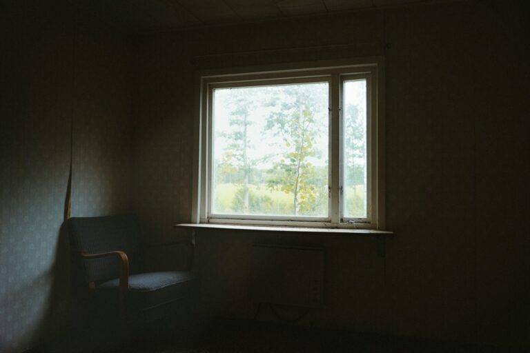Silla vacía junto a una ventana en una habitación en penumbra, imagen sobre la ausencia de una persona desaparecida