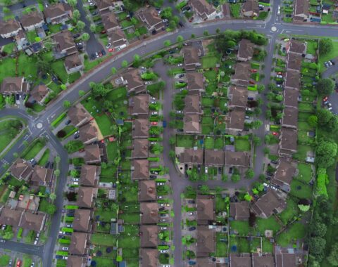 Vista aérea de una ciudad con manzanas, casas y calles, ilustrando el catastro de inmuebles
