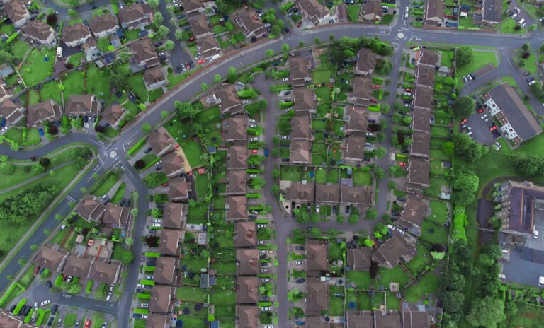 Vista aérea de una ciudad con manzanas, casas y calles, ilustrando el catastro de inmuebles